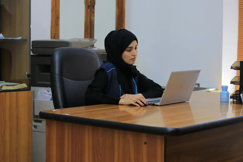A Nahbal team member working on a laptop at her desk