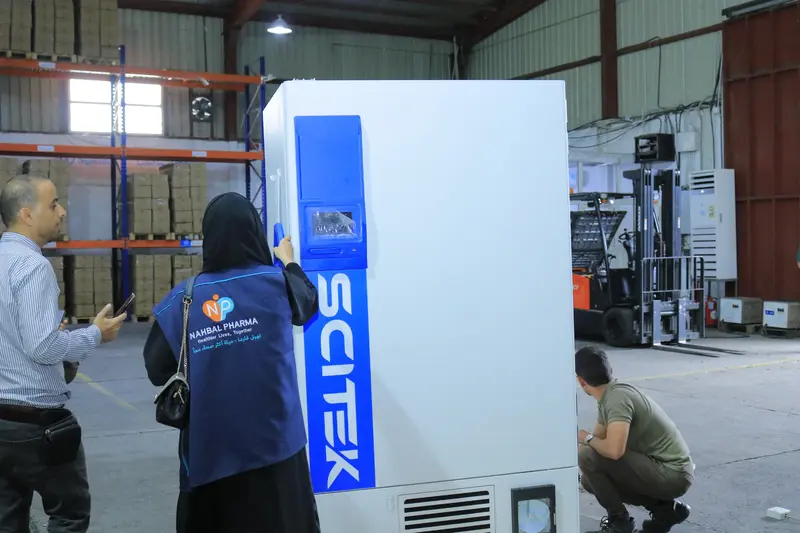 Nahbal team supervising the handling of a large device inside the warehouse
