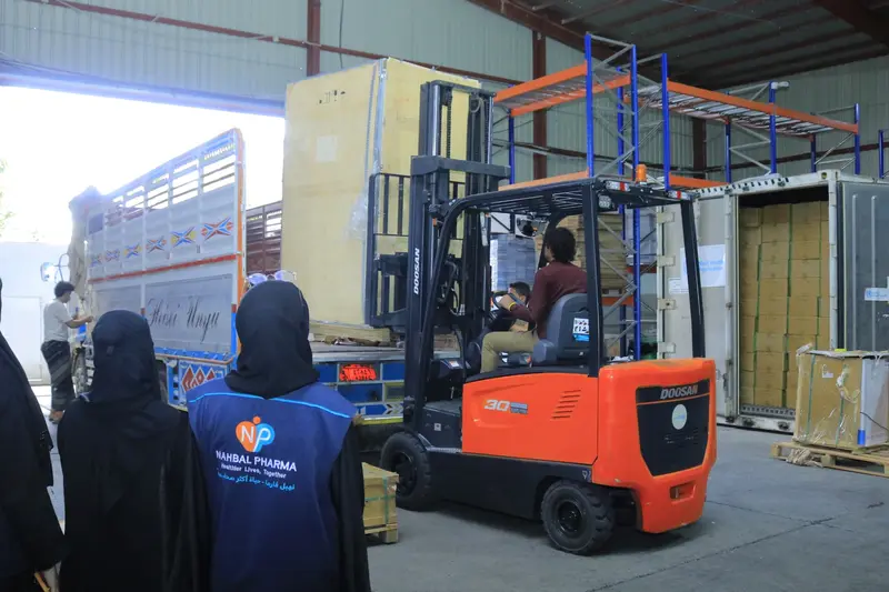 A forklift moving large equipment under Nahbal team supervision